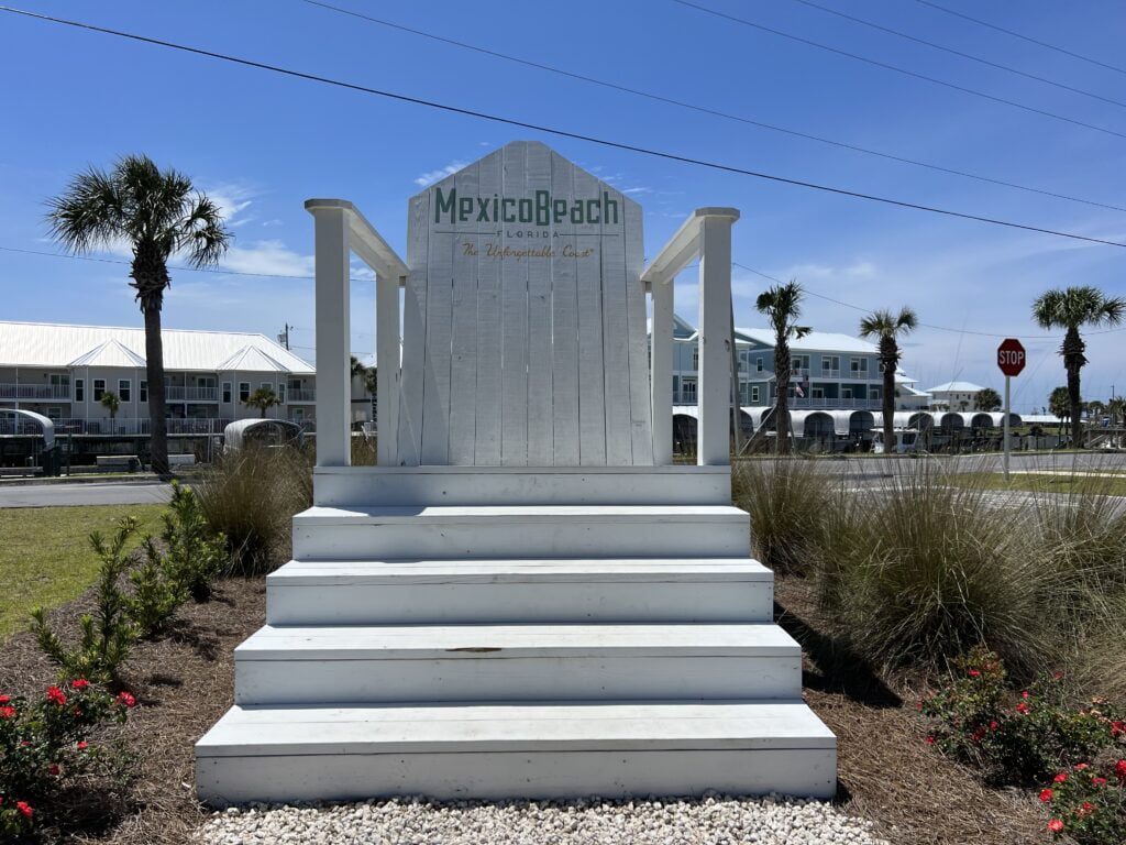 Oversized white beach chair for photo opportunities for tourists in Mexico Beach, outside against a blue sky