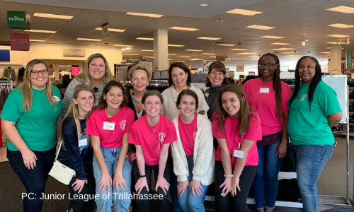 12 Junior League members posing for a photo inside Kohl's at their annual Kids Boutique back to school shopping event.